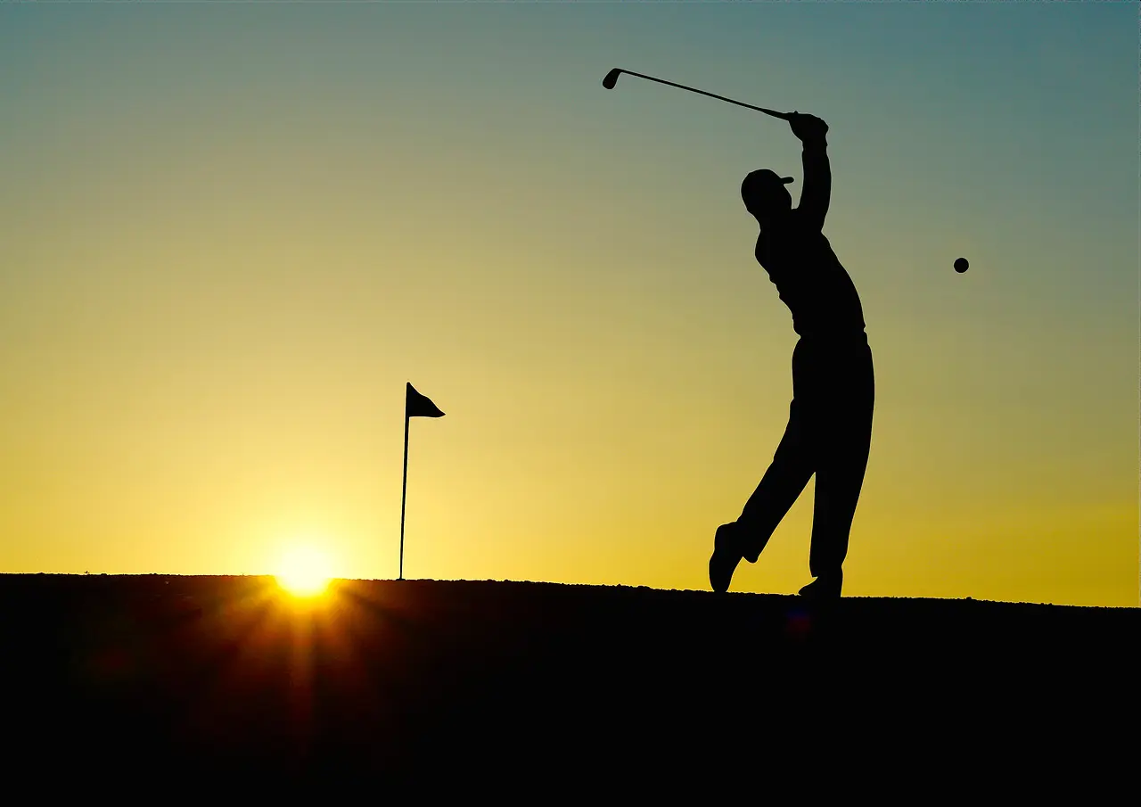 Golfspiller i silhuet ved solnedgang